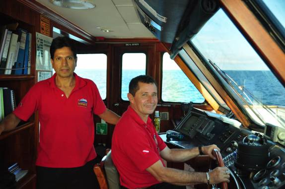 O Capitão Vitor e o Jairo na cabine de comando do nosso barco, próximo à Isla Santiago, em Galápagos